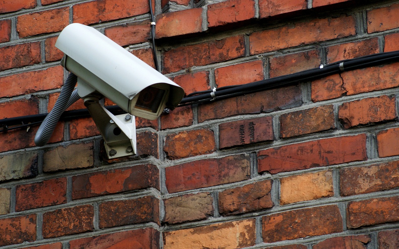une caméra de surveillance fixée sur un mur en briques
